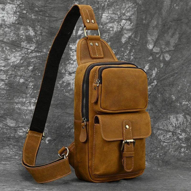 Stylish leather sling bags for travel displayed with a watch and wallet on a brick background