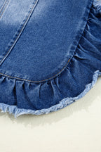 Close-up of a blue denim skirt with ruffled hem on a light background