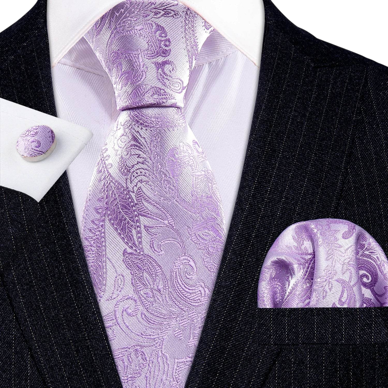 Purple paisley tie set with matching pocket square and cufflinks on a black suit.