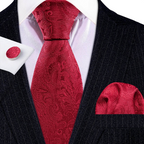 Red paisley tie set with matching pocket square and cufflinks on a black suit.