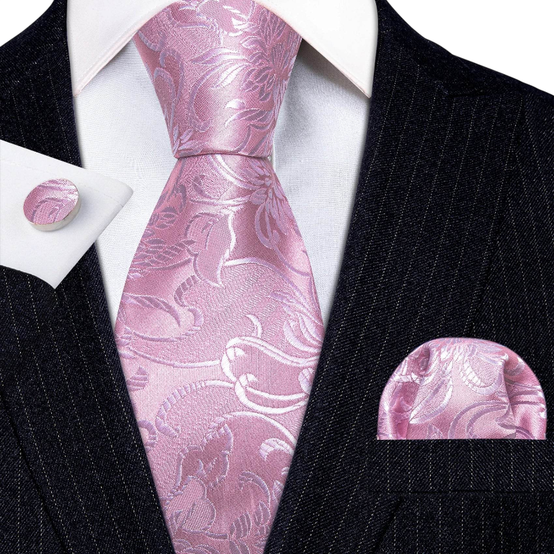 Pink paisley tie set with matching pocket square and cufflinks on a black suit.